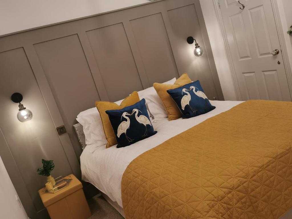 een slaapkamer met een bed met blauwe en witte kussens bij Fell View Cottage in Cockfield