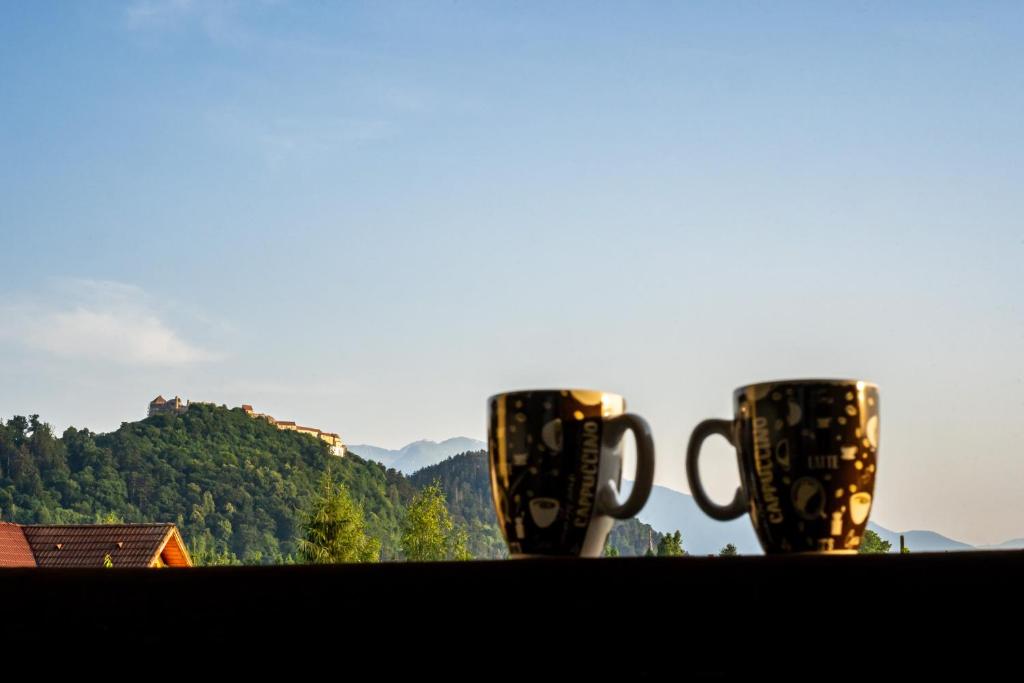 two coffee cups sitting on top of a table at APARTAMENT CETATE VIEW in Râşnov