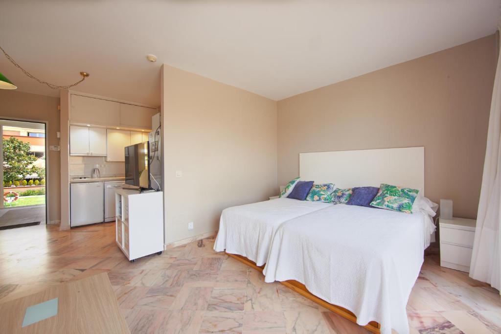 1 dormitorio con 1 cama blanca y cocina en Romana Playa 637, en Marbella