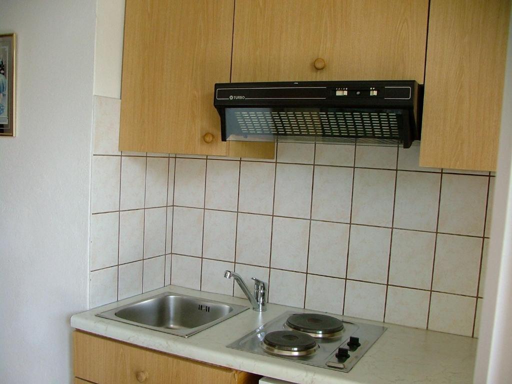 una cocina con fregadero y microondas en Pension Weiss, en Drobollach am Faakersee