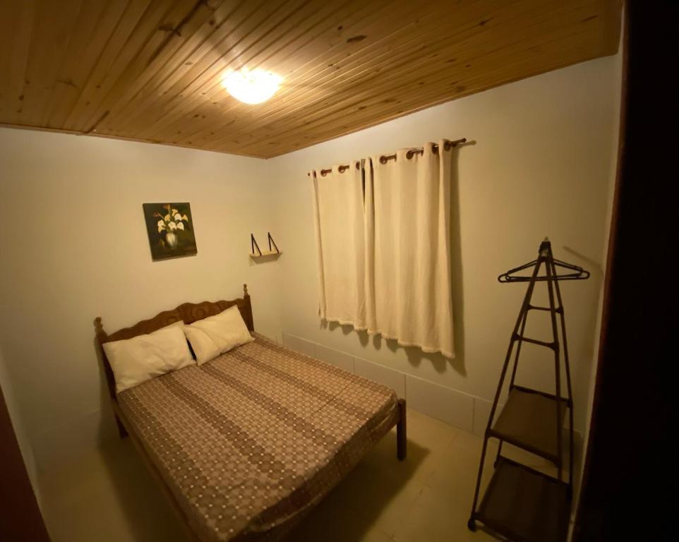 a bedroom with a bed and a wooden ceiling at Chalé Flor da Serra in Conceição da Ibitipoca