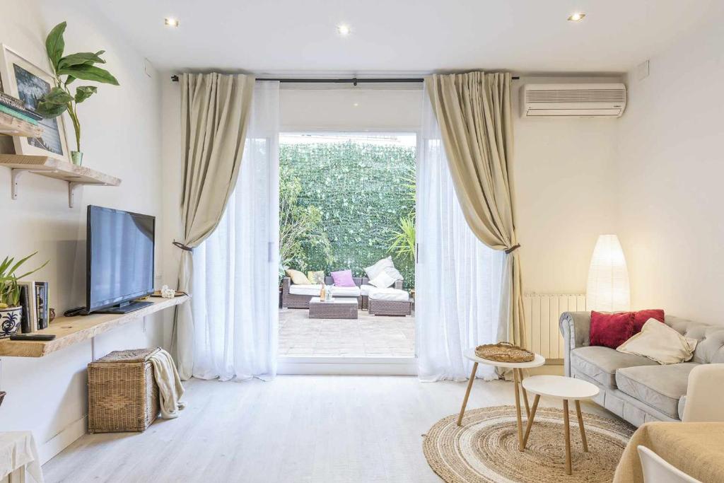ein Wohnzimmer mit einem Sofa und einem TV in der Unterkunft Apartment Gaudi in Sitges