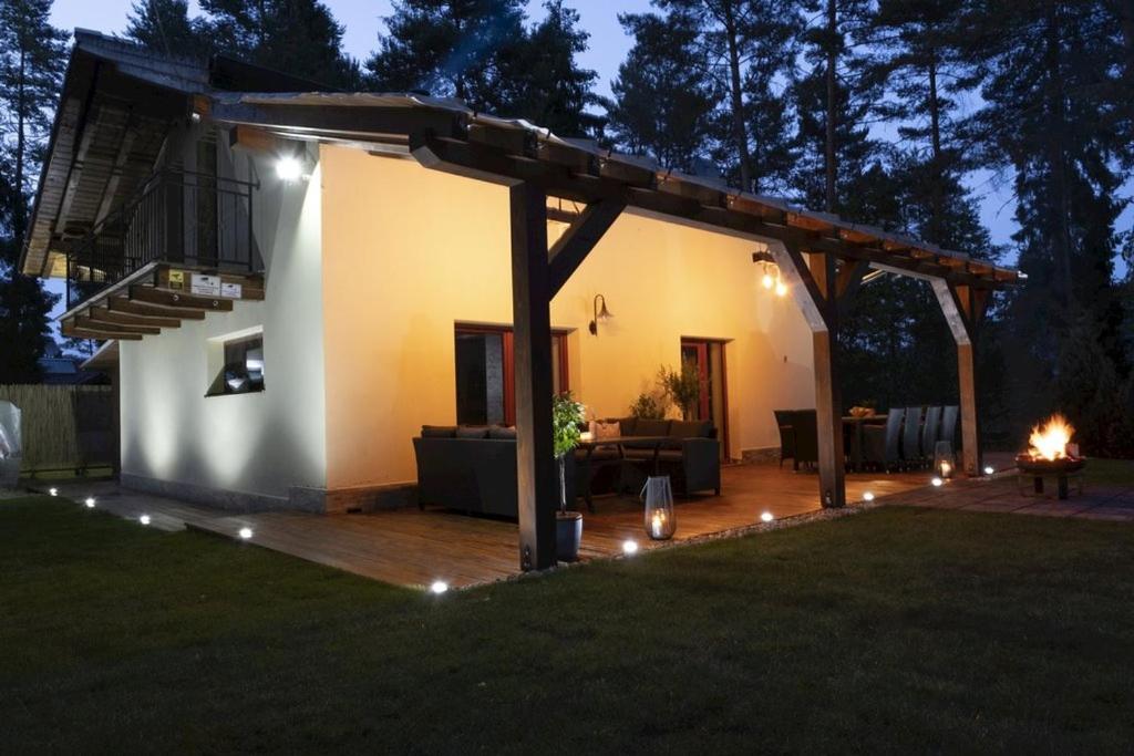 una terraza en el patio trasero con pérgola por la noche en Chata Emily, en Smižany