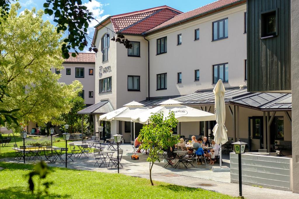 a group of people sitting at tables in front of a building at JUFA Hotel Maria Lankowitz in Maria Lankowitz