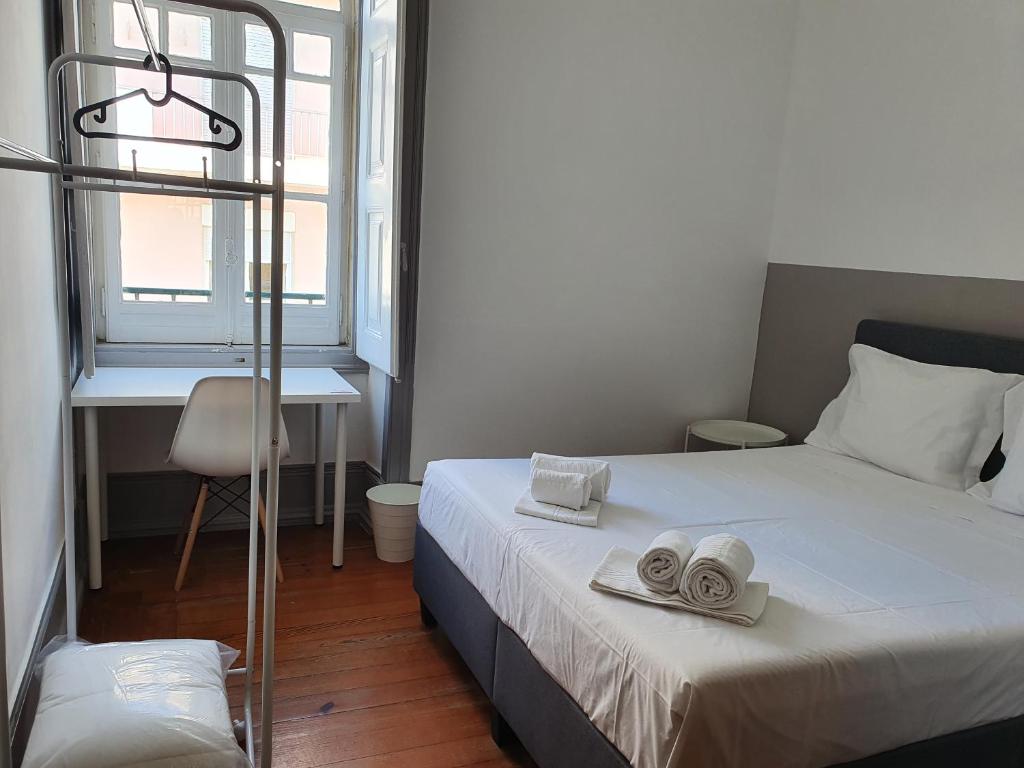 a bedroom with a bed with two towels on it at Baixa Terrace Hostel in Faro