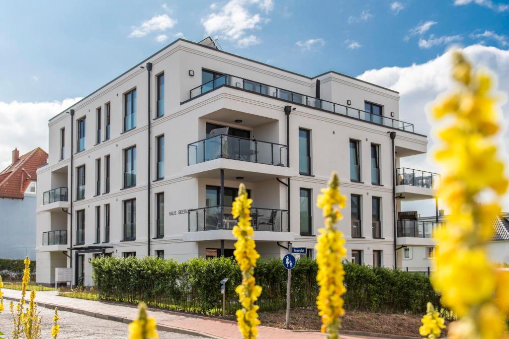 a white building with yellow flowers in front of it at Seeblick Strandgold, exklusive Wohnung mit Meerblick in Wangerooge