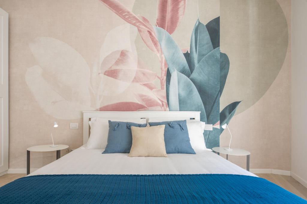 um quarto com uma cama e um mural de plantas em Brera Charming Apartments R&R em Milão