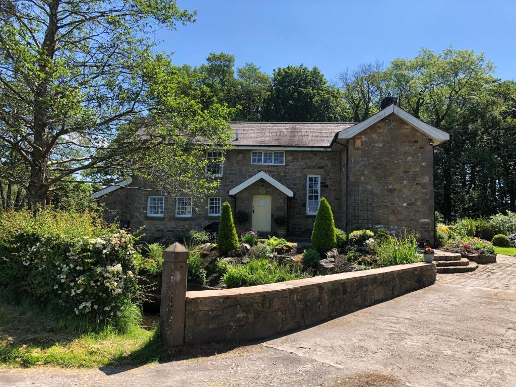 a stone house with a garden in front of it at Picket Post House Bed & Breakfast in Catterall