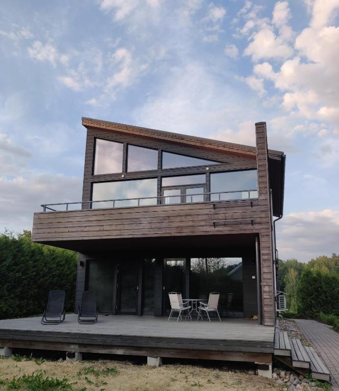 a house with glass doors and a deck with chairs at Villa Gardens in Imatra
