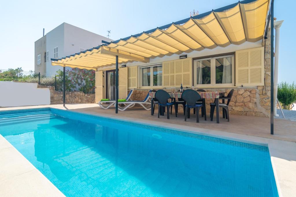 a patio with a table and chairs next to a swimming pool at Can Clavell in Artá