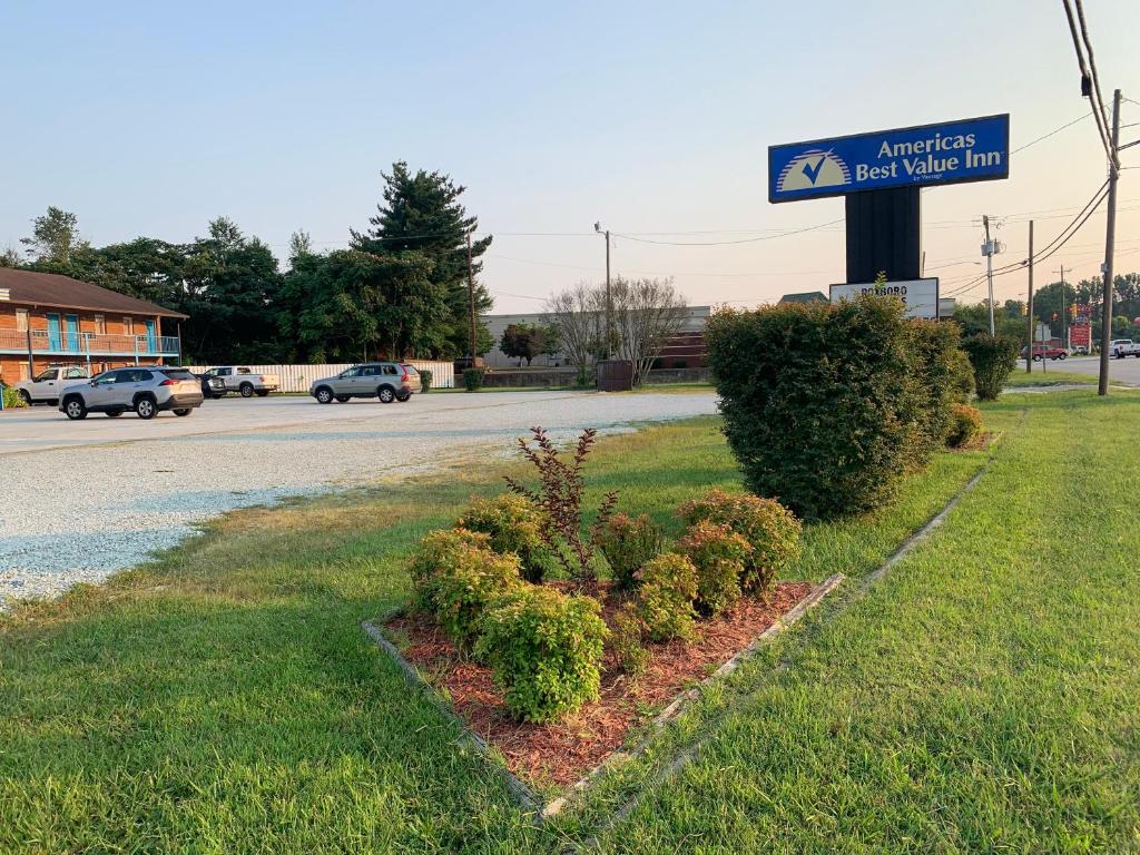 a sign for an american hot water inn next to a street at Americas Best Value Inn - Roxboro in Roxboro