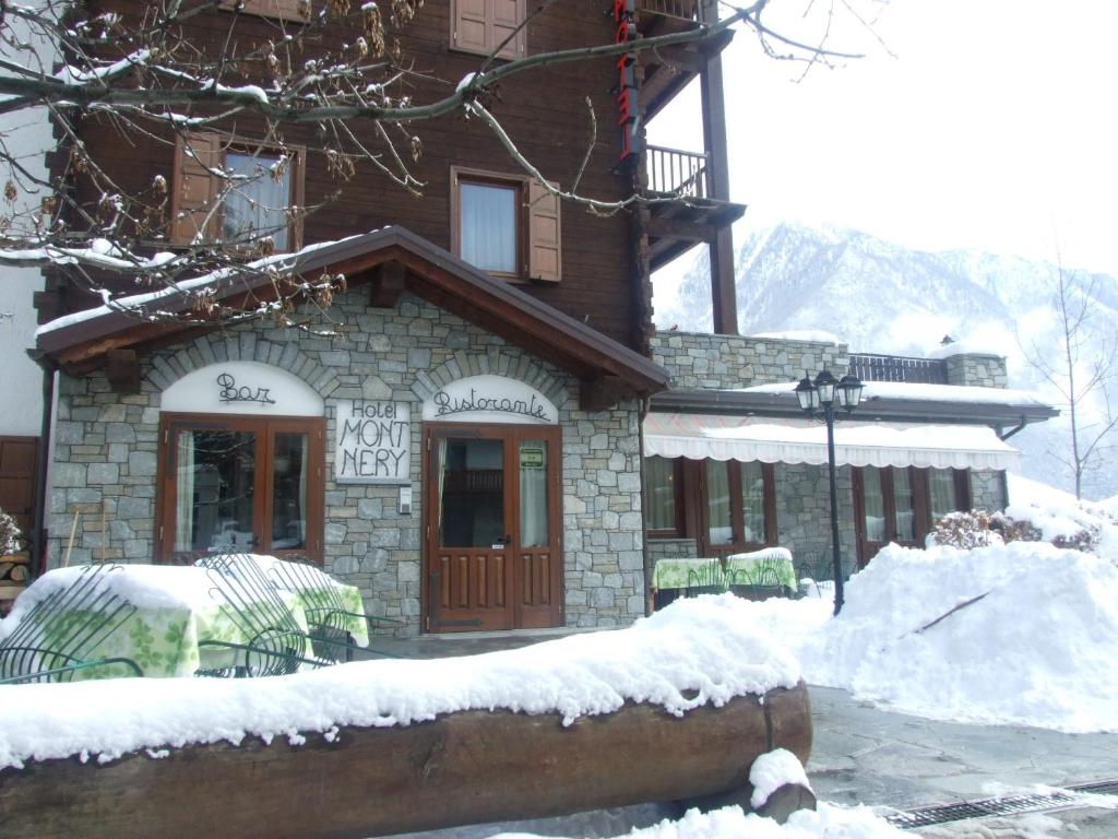 un edificio con sillas cubiertas de nieve delante de él en Hotel Mont Nery, en Challand Saint Anselme