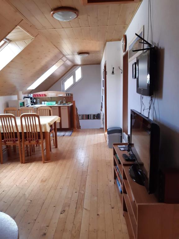 a living room with a dining table and a tv at Chalupa Helena na Poráči in Poráč