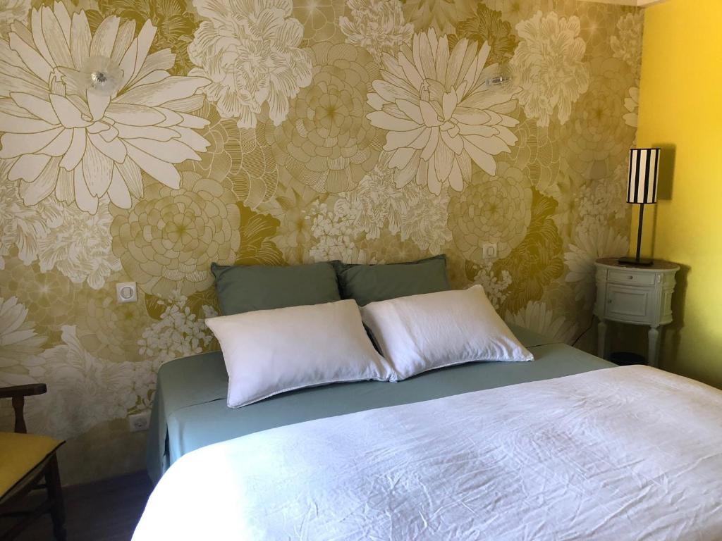 a bedroom with a bed with a flower wallpaper at La Gatille in Villié-Morgon