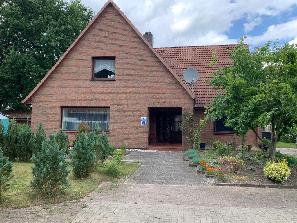 Pension A1 Stuckenborstel في Sottrum: منزل من الطوب الأحمر وامامه حديقة