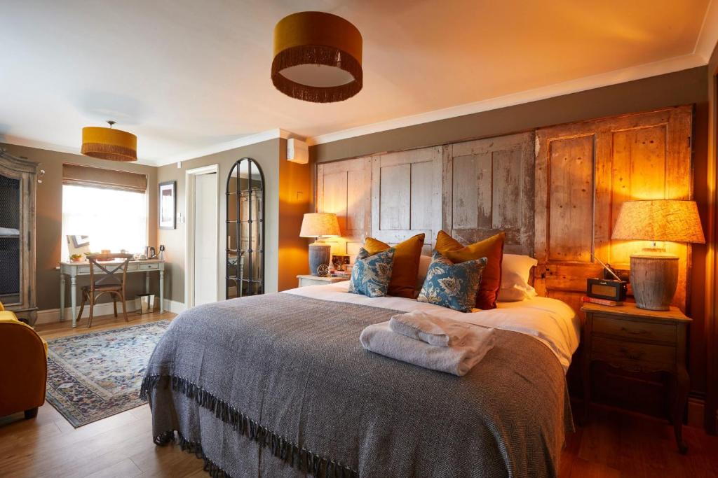 a bedroom with a large bed with a wooden headboard at The Quarrymans Arms in Corsham