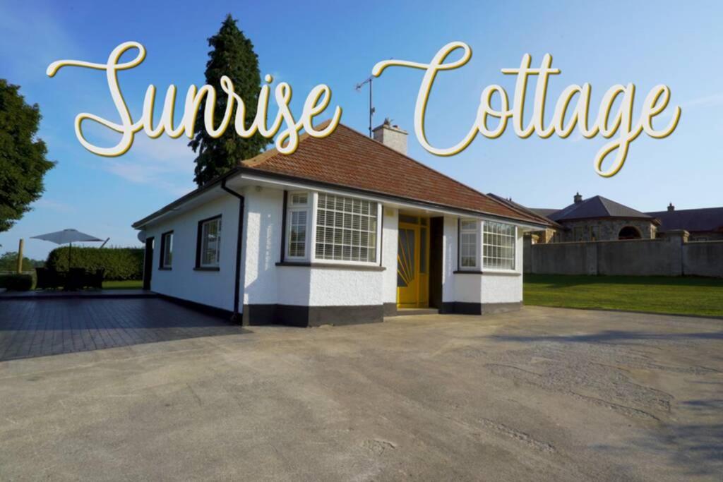 a house with a large driveway in front of it at Sunrise Cottage on shores off Lough Gowna in Scrabby