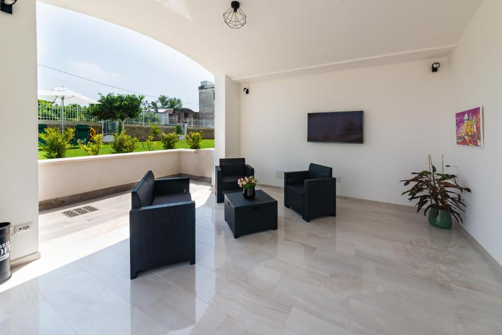 a living room with black chairs and a large window at IL GIARDINO in Procida