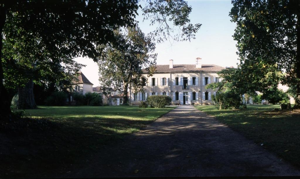 Labastide-dʼArmagnac的住宿－帕拉達城堡酒店，前面有树木的大白色房子