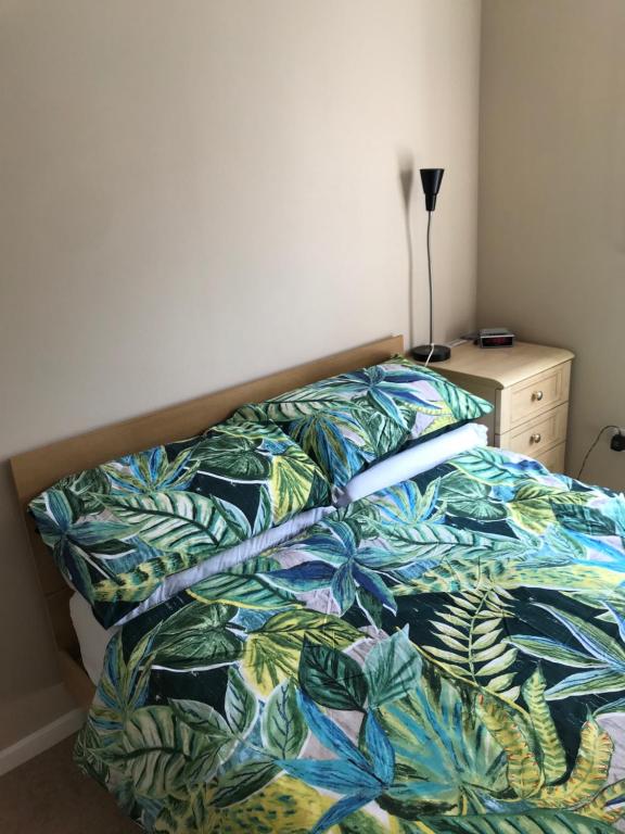 a bed with a colorful comforter in a bedroom at Homestay Norwich in Norwich