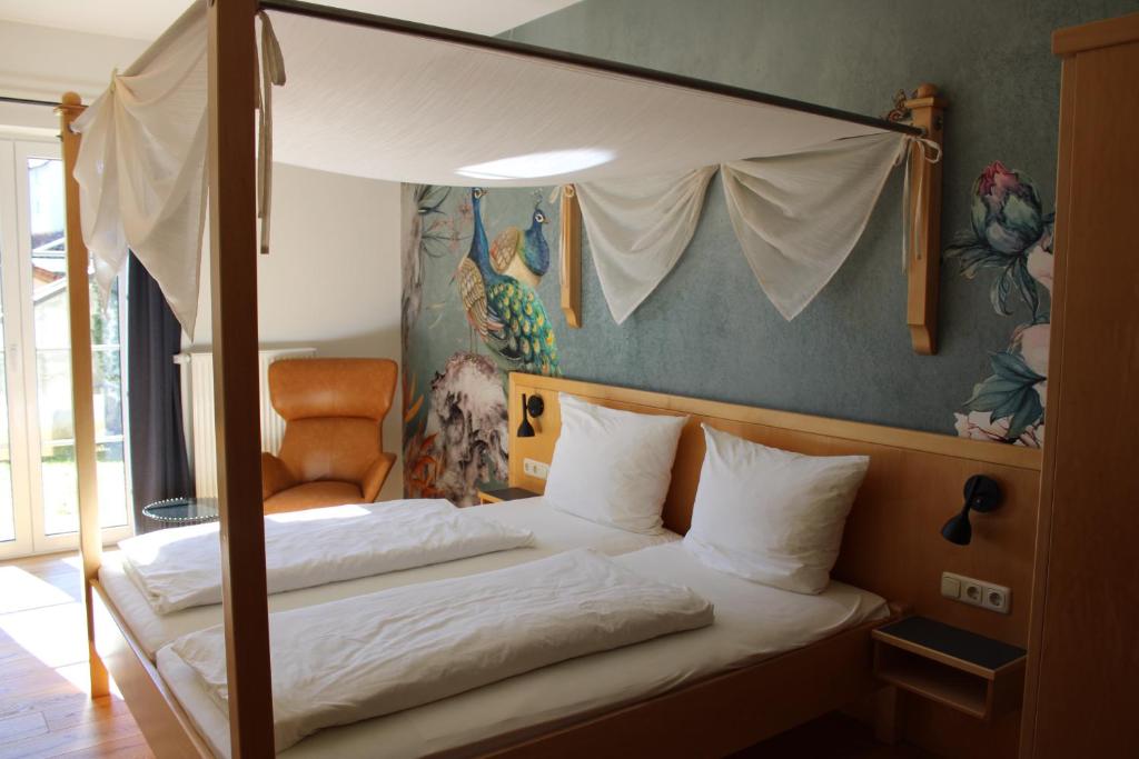 a bedroom with a canopy bed and a chair at Gasthof Berghof in Presseck