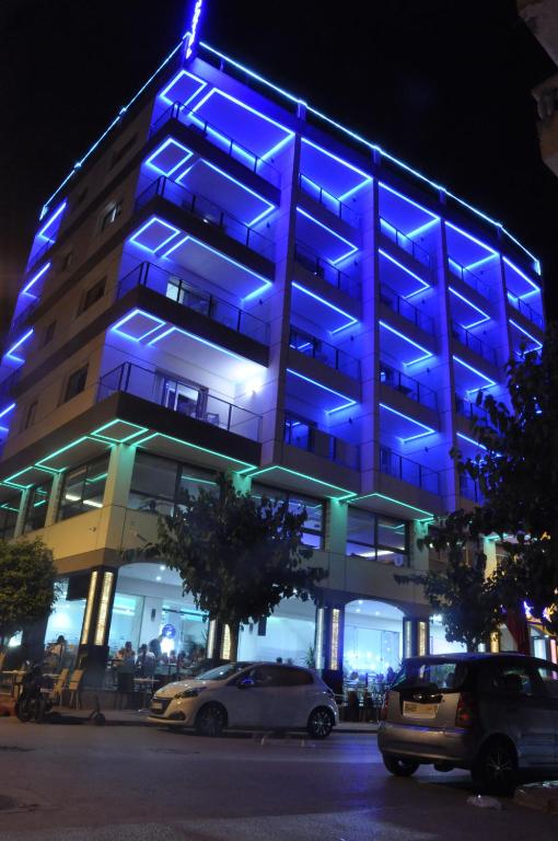 a blue building with cars parked in front of it at Hôtel laluna bay in M'diq