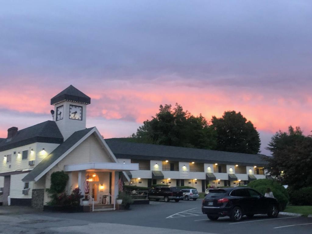 a building with a clock tower in a parking lot at The Black Mountain Inn in Brattleboro