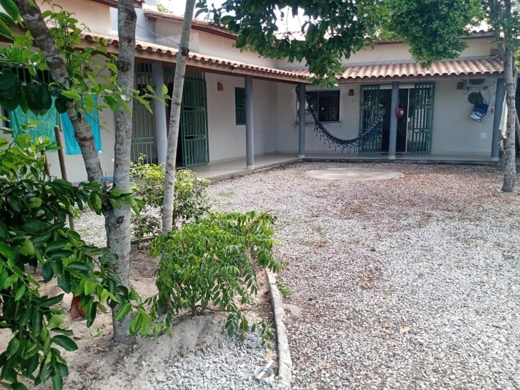 een huis met een poort en bomen ervoor bij Aconchego Baiano - Coroa Vermelha - Cabrália - BA. in Coroa Vermelha