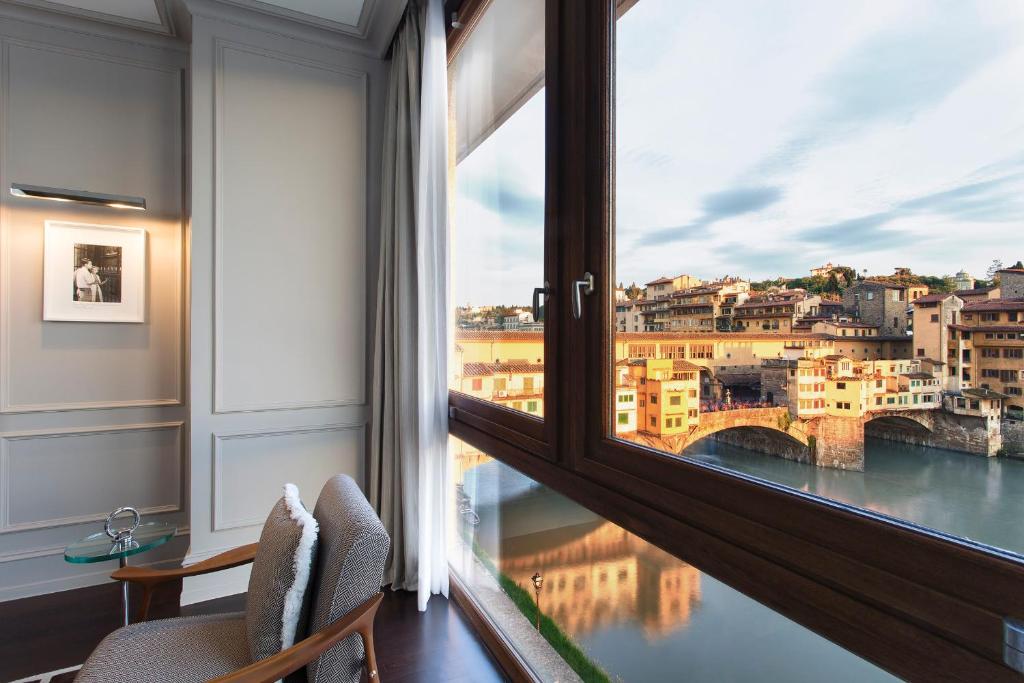 Cette chambre dispose d'une fenêtre offrant une vue sur un pont. dans l'établissement Portrait Firenze - Lungarno Collection, à Florence