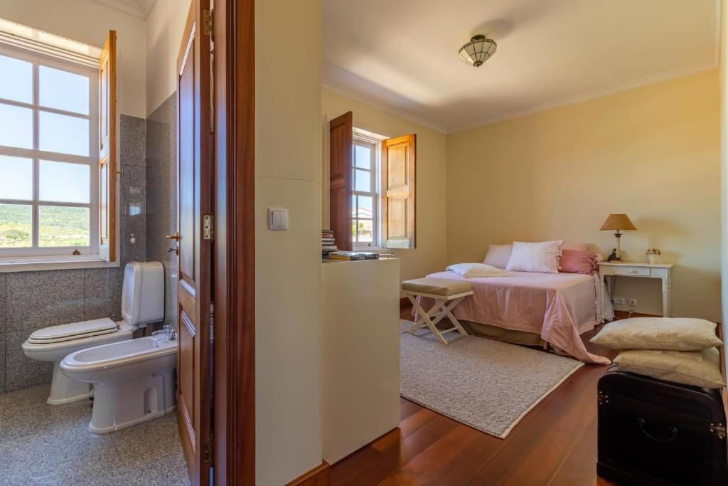 a bedroom with a bed and a bathroom at Casa da Pergula in Freixo de Espada à Cinta