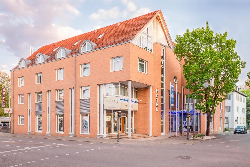un grand bâtiment en briques au coin d'une rue dans l'établissement Hotel am Schillerpark, à Esslingen am Neckar