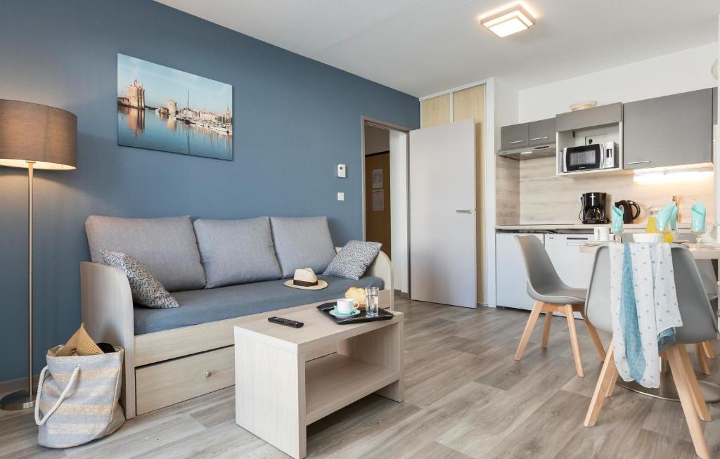 a living room and kitchen with a couch and a table at Résidence Odalys Archipel in La Rochelle