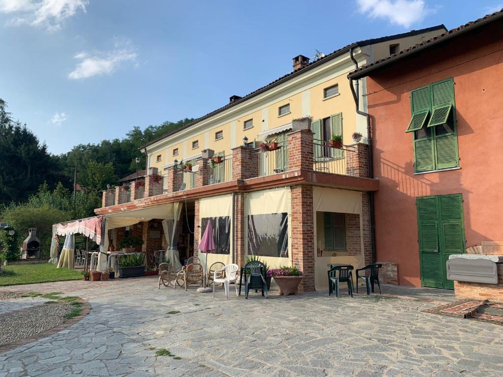 ein großes Gebäude mit Tischen und Stühlen davor in der Unterkunft Casa Tavasso in Asti