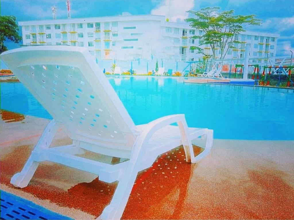 uma cadeira de balanço branca sentada ao lado de uma piscina em Apartamento privado a 2 kilometros del Parque del Café em Montenegro