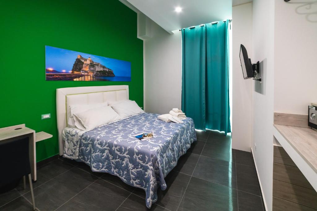 una camera con un letto con una parete verde di B&b Onda Napoli a Napoli