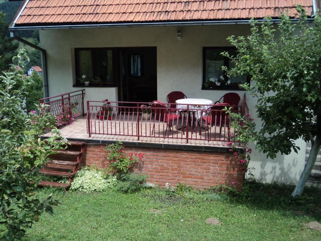 uma varanda com uma mesa e cadeiras numa casa em Zeleni dom em Nova Varos