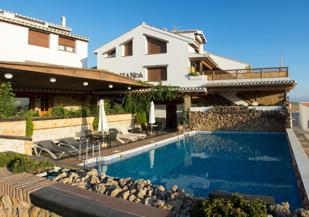 a villa with a swimming pool and a house at Alhanda Apartahotel in Benamaurel