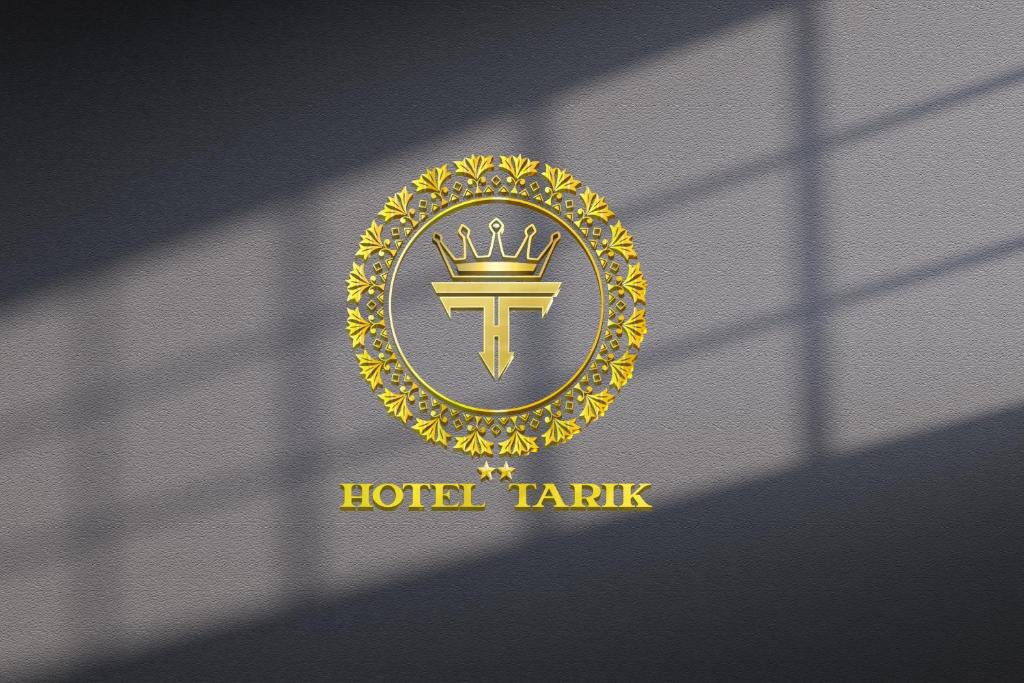 ein Logo für eine Hotel Taza mit goldenem Wappen in der Unterkunft HOTEL TARIK Fnideq in Fnideq