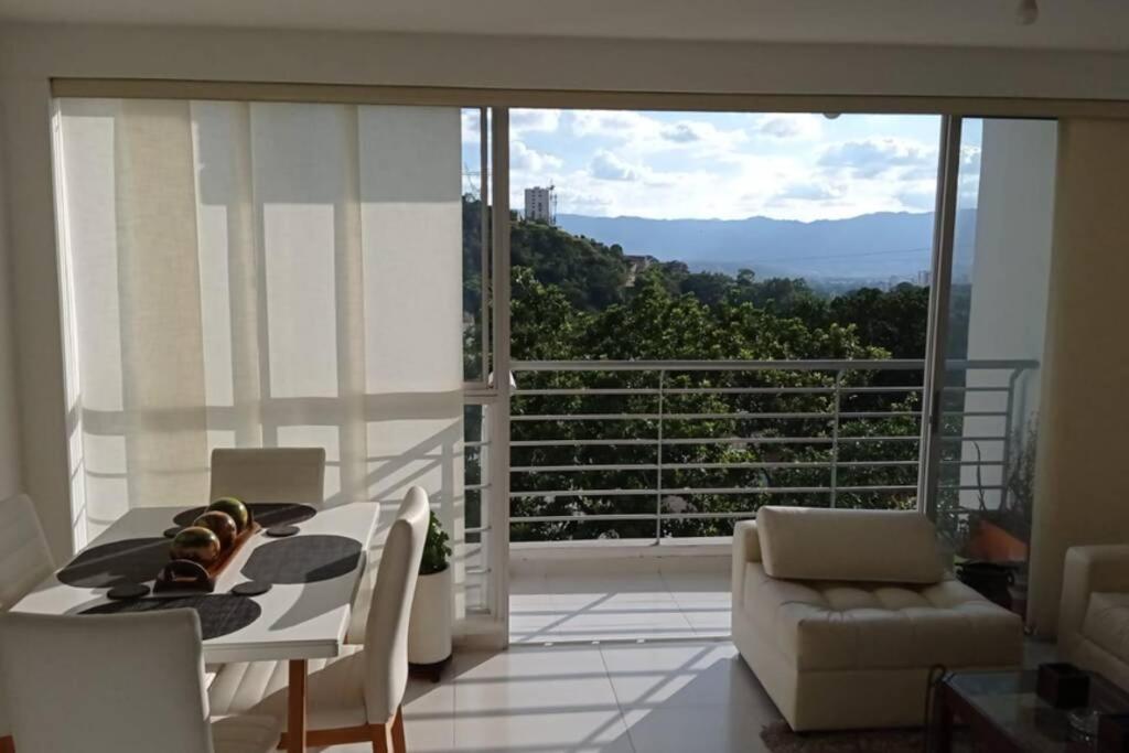 a dining room with a table and chairs and a balcony at Hermoso apartamento, cerca Hospital Internacional in Floridablanca