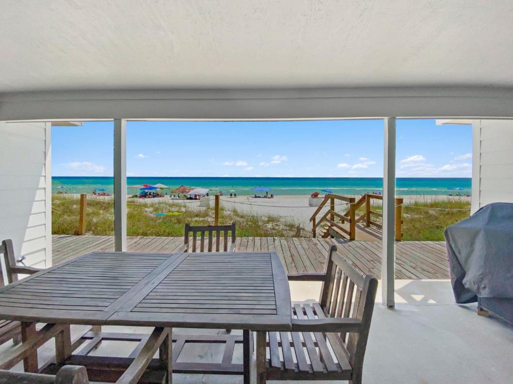 a table and chairs on a deck with a view of the beach at On the Beach Townhouse in Inlet Beach