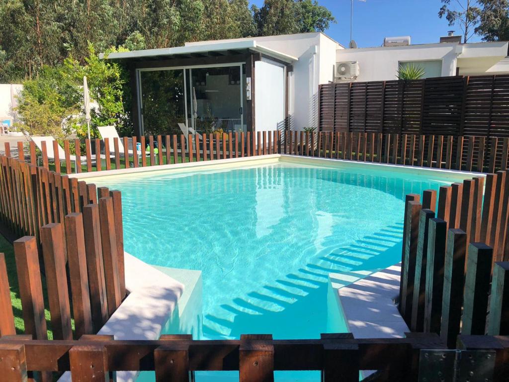 - une piscine dans un jardin avec une clôture en bois dans l'établissement Villas do Rosal, à Boa Vista de Cima