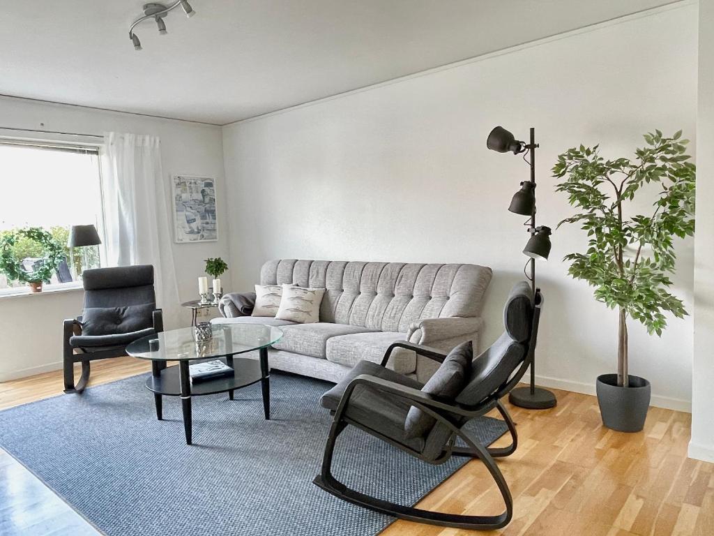 een woonkamer met een bank en een tafel bij Björkö, lägenhet nära bad och Göteborg in Göteborg