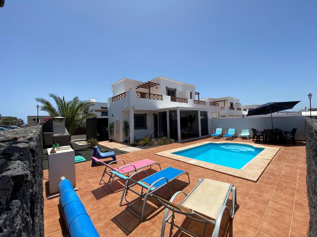 una villa con piscina frente a una casa en Varadero Nauplius, en Playa Blanca