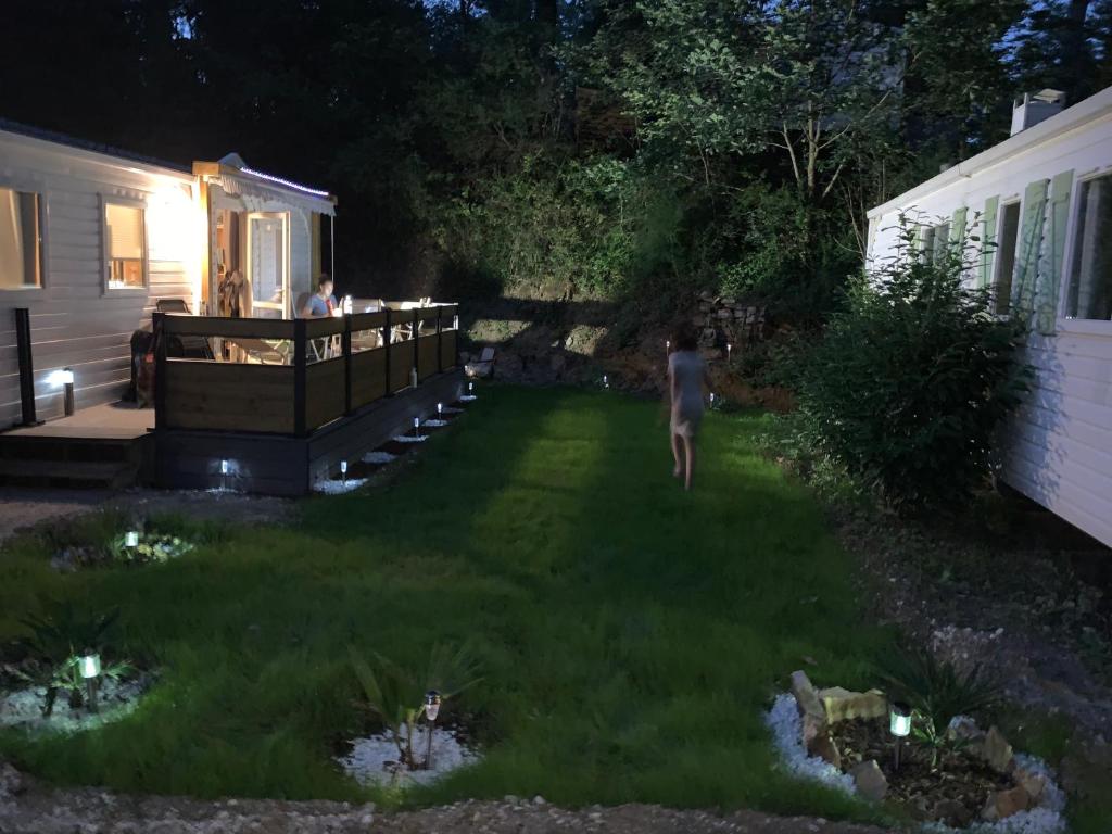 une personne debout dans une cour la nuit dans l'établissement Les mobil homes d’oliver rob, à Saint-Chéron