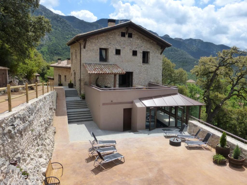 a house with a patio with chairs and a building at Viladomatrural in La Nou
