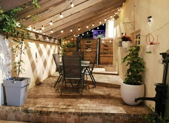 a patio with a table and chairs and lights at Appartement cosy au coeur du Beaujolais in Saint-Lager