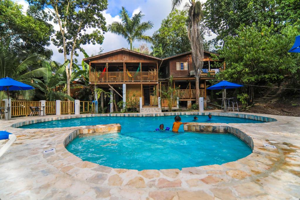 een zwembad met een huis op de achtergrond bij Zimbali Culinary Retreats in Negril