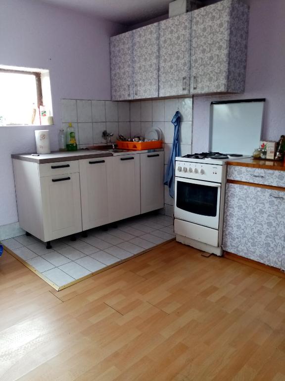 a kitchen with white cabinets and a white stove top oven at Carlitos in Gospić