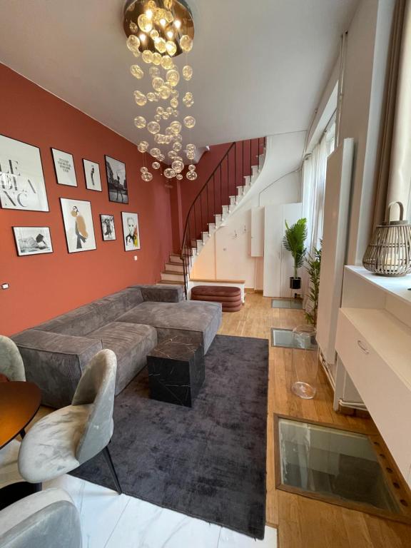 - un salon avec un grand canapé et un escalier dans l'établissement Canal Saint Martin apartments, à Paris