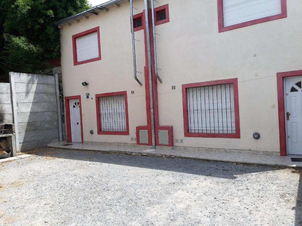 Apartamento El Calvario 3 في تانديل: مبنى أبيض بأبواب ونوافذ حمراء